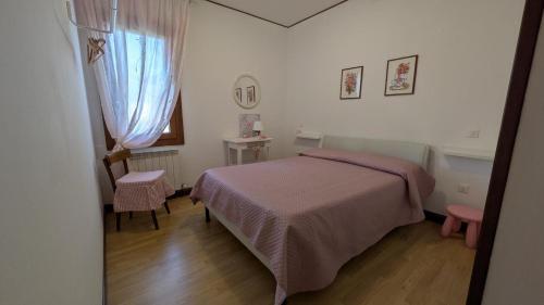 a bedroom with a bed and a desk and a window at Oliva's House con giardino in Palazzolo dello Stella