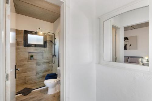 a bathroom with a toilet and a mirror at Casa Jonas in Tías