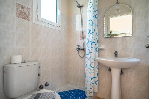 a bathroom with a toilet and a sink and a mirror at Anemona studio C in Kefallonia