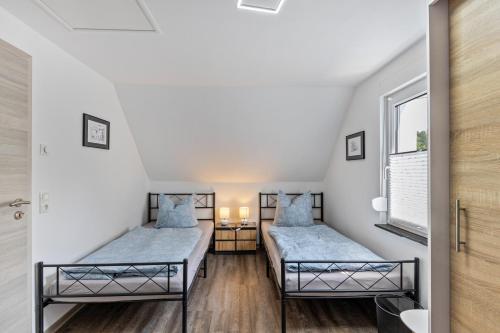 two beds in a room with white walls at Ferienhaus Heidi in Bad Düben