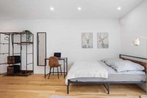 a white bedroom with a bed and a desk at Global Bnb - Ay Homes in Augsburg