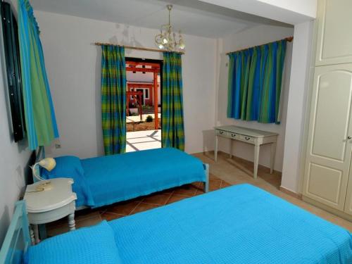 a living room with two blue beds and a desk at Sami Beach Villas Fedra in Sami