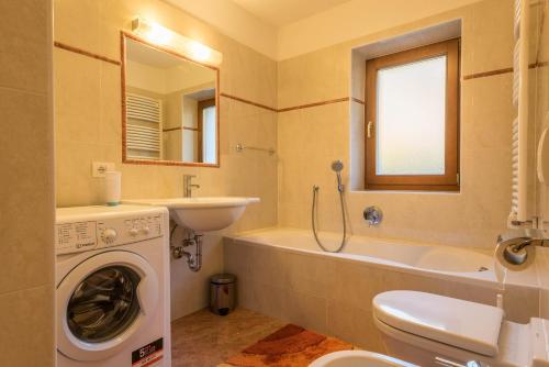 a bathroom with a washing machine and a sink at Ferienwohnung Sella Seis in Siusi