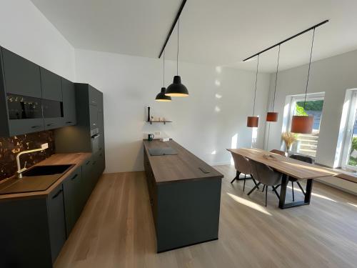 a kitchen with a table and a dining room at Design Apartment Flair u Komfort in Meschede