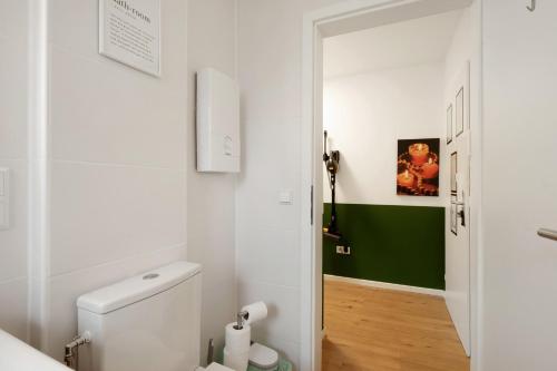 a bathroom with a white toilet and a green wall at Business Apartment in Oberkochen in Oberkochen