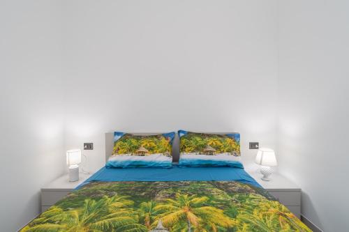 a bedroom with a blue bed with palm trees at Villetta Vanessa in Avola