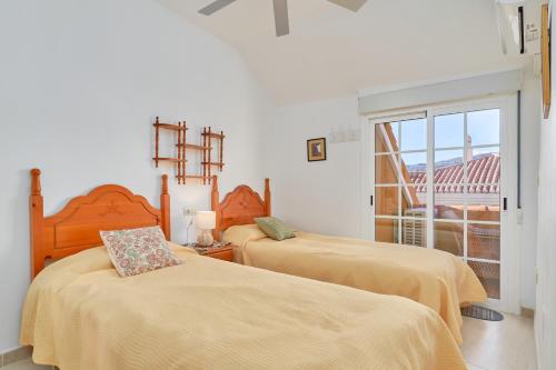 a bedroom with two beds and a balcony at Casa Venus in Salobreña