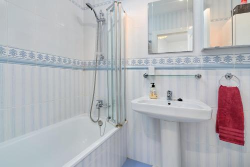 a white bathroom with a sink and a shower at Casa Venus in Salobreña