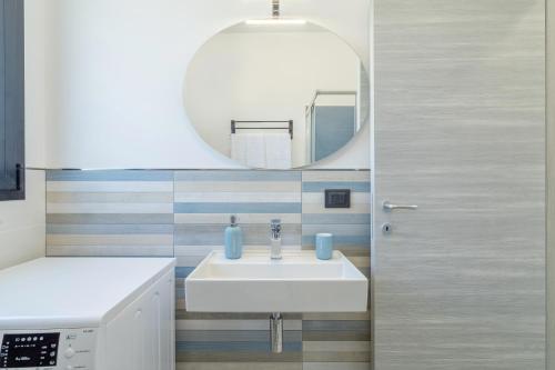 a bathroom with a white sink and a mirror at Villetta Vanessa in Avola