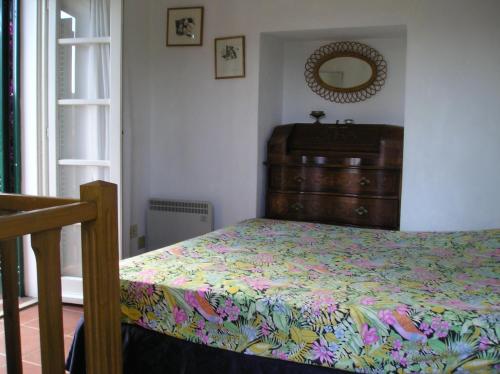 a bedroom with a bed and a dresser and a mirror at Ester Home Procchio Mare E Sole in Marciana