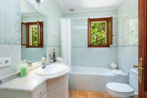 a bathroom with a sink and a tub and a toilet at Pomeres Nou in Sa Coma