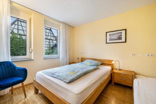 a bedroom with a bed and a blue chair at Ferienwohnung Gäufelden 120 Qm in Gäufelden
