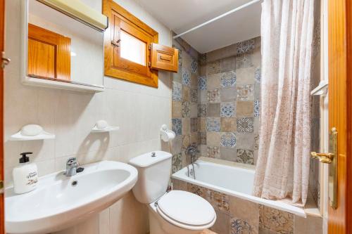 a bathroom with a sink and a toilet and a tub at La Noria 3 in El Pozo de los Frailes