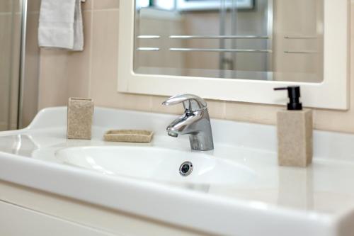 a sink in a bathroom with a mirror at Villa Goyo in Cala en Bosc