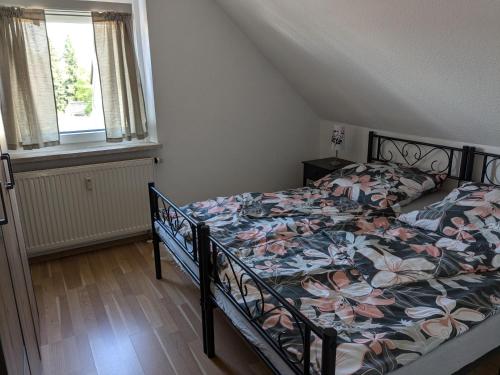 a bedroom with a bed with a floral comforter at Ferienwohnung Alafia in Veitsbronn