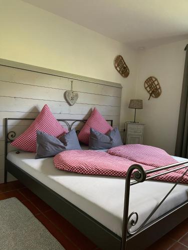 a bed with pink and blue pillows on it at Ferienwohnung Alpenherz 80qm in Blaichach