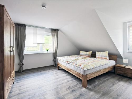a bedroom with a bed and two windows at Adlerhorst in Baiersbronn