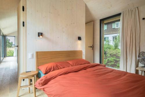ein Schlafzimmer mit einem großen Bett und einem Fenster in der Unterkunft Tiny House Lachen in Wangen im Allgäu