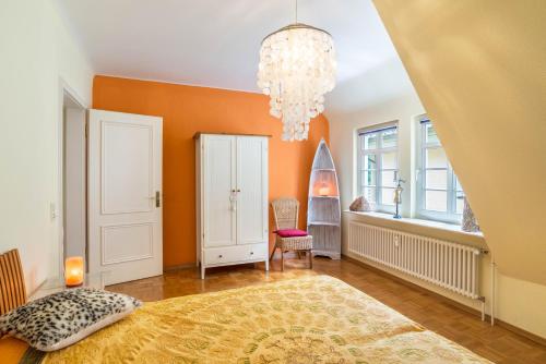 a bedroom with orange walls and a chandelier at Ferienwohnung Saline in Bad Wildbad