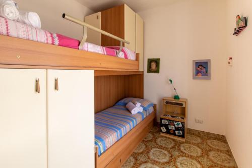 a small bedroom with a bunk bed and a shelf at La casa di Ulisse 2 in Ispica