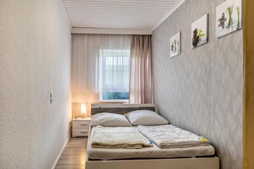 a small bedroom with a bed in a room with a window at Günthers Wattstube in Schweiburg