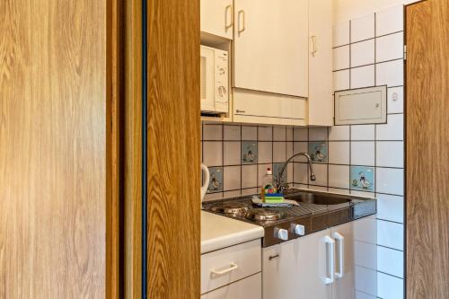 a kitchen with white cabinets and a sink at Günthers Wattstube in Schweiburg