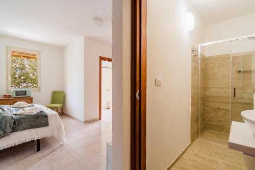 a bedroom with a bed and a bathroom with a shower at Andromeda's Rooms in Otranto