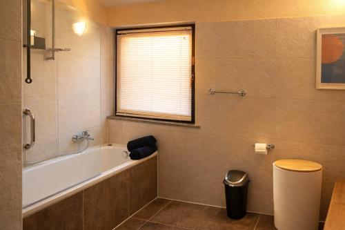 a bathroom with a bath tub and a window at Central Penthouse Luino in Luino