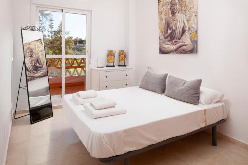 a bedroom with a large bed with towels on it at Apartamento Baviera Golf 002 in Vélez-Málaga