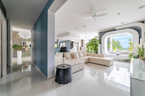 a living room with a couch and a table at Prestigieuse Villa Spa 2 Piscines in Saint-Gély-du-Fesc