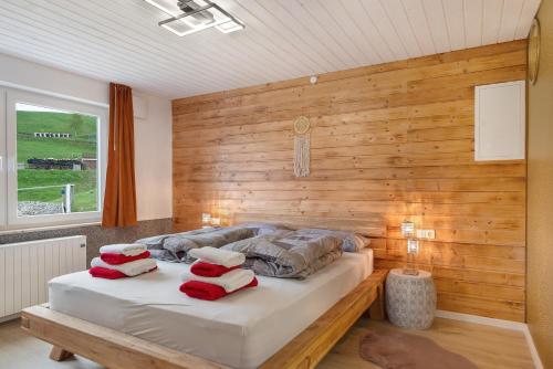 a bedroom with a wooden wall and a bed with pillows at Ferienwohnung im Grünen in Oberried