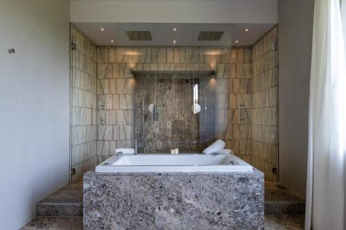 a bath tub in a bathroom with a stone tub at Suite Deluxe Torre in San Gimignano