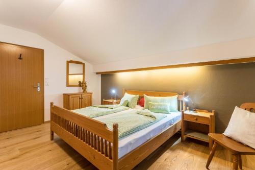 a bedroom with a wooden bed and a chair at Ferienwohnung Riepl in Schliersee