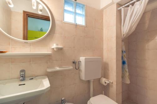 a bathroom with a toilet and a sink and a mirror at Simona Giardino in Fetovaia