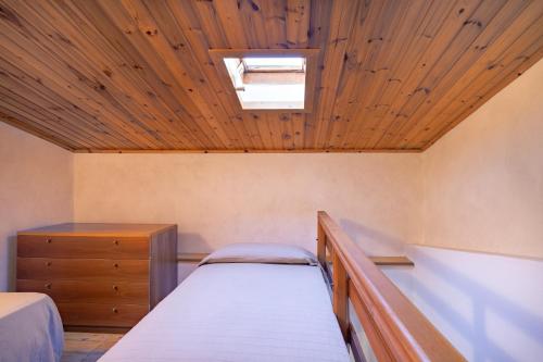 a bedroom with two beds and a wooden ceiling at Simona Giardino in Fetovaia