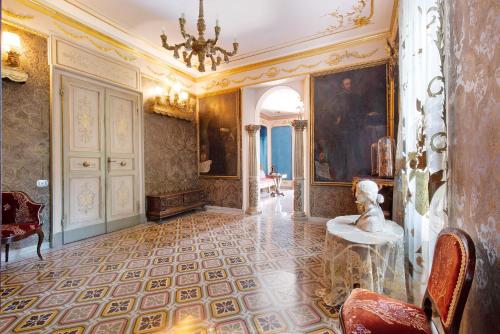 a room with a chandelier and a statue in it at Historic Villa Argegno Como lake in Dizzasco