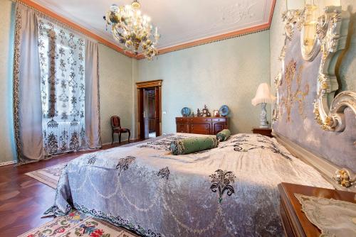 a bedroom with a large bed and a chandelier at Historic Villa Argegno Como lake in Dizzasco
