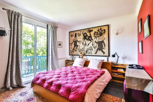 a bedroom with a large pink bed and a window at Txori Etxea in Arcangues