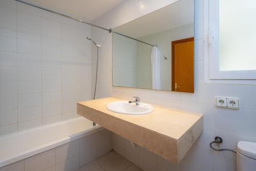 a bathroom with a sink and a mirror and a tub at Catalina 3b in Port de Pollensa