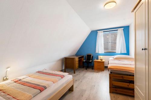 a bedroom with two beds and a desk and a window at Lebensblume in Ilshofen