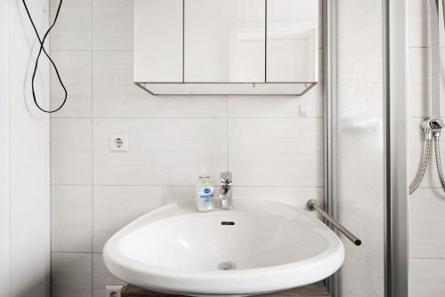 a white sink in a bathroom with a shower at Lebensblume in Ilshofen