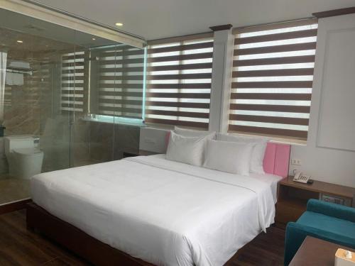a bedroom with a white bed and a blue chair at Hanoi Central Westlake Hotel in Hanoi