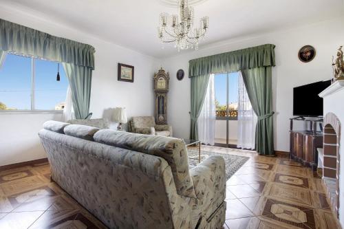 a living room with a couch and a clock at Vivenda Ribeiro - B in Lagos