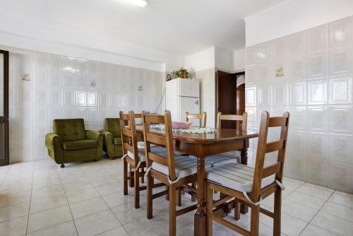 a kitchen with a table and chairs and a refrigerator at Vivenda Ribeiro - B in Lagos