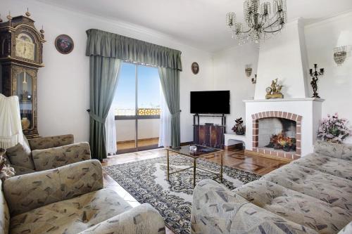a living room with a fireplace and a tv at Vivenda Ribeiro - B in Lagos
