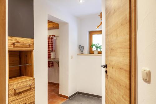 a door leading into a kitchen with wooden cabinets at Haus Niklos - Waldeck in Grainau
