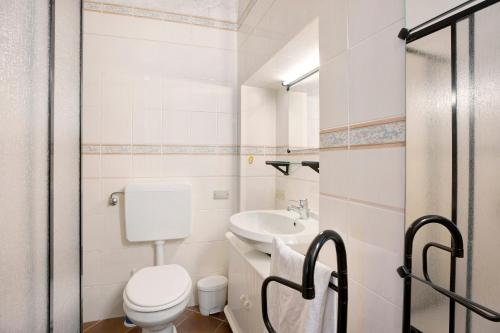 a white bathroom with a toilet and a sink at in Villa Belli in Miasino