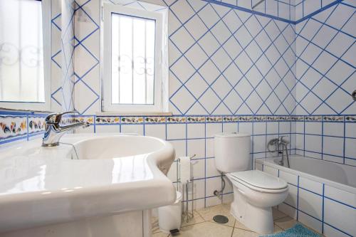 a bathroom with a tub sink and a toilet at Casa das Romanzeiras in Carvoeiro