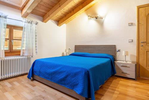 a bedroom with a bed with a blue blanket at Maso Gigi in Castel Ivano