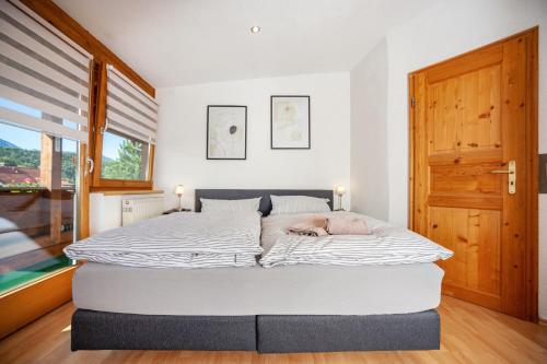 a bed in a bedroom with a dog laying on it at Paulas Ferienwohnung Koenigscard in Füssen